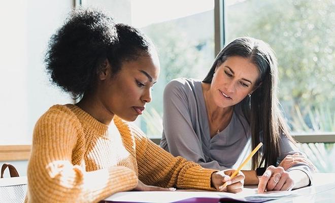 Counselor helping student at table